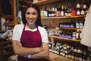 female-staff-standing-with-arms-crossed-in-super-market_min